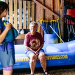 An older lady sitting on a raft at Raft Outdoor Adventures.