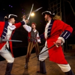A pirate fights off two members of a navy at a Pirates dinner & show in Pigeon Forge.