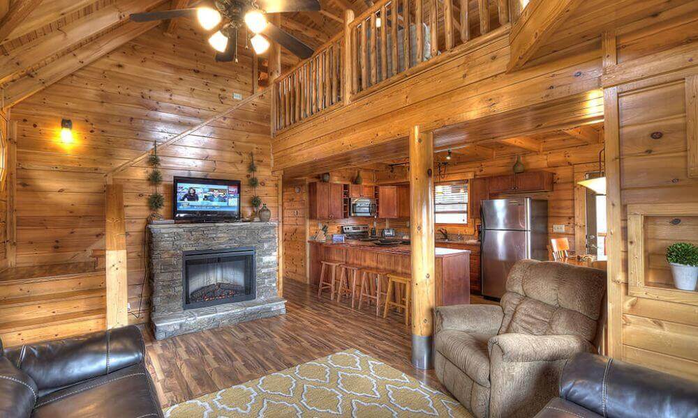 A cozy cabin with a fireplace and a television, perfect for a relaxing getaway in nature.