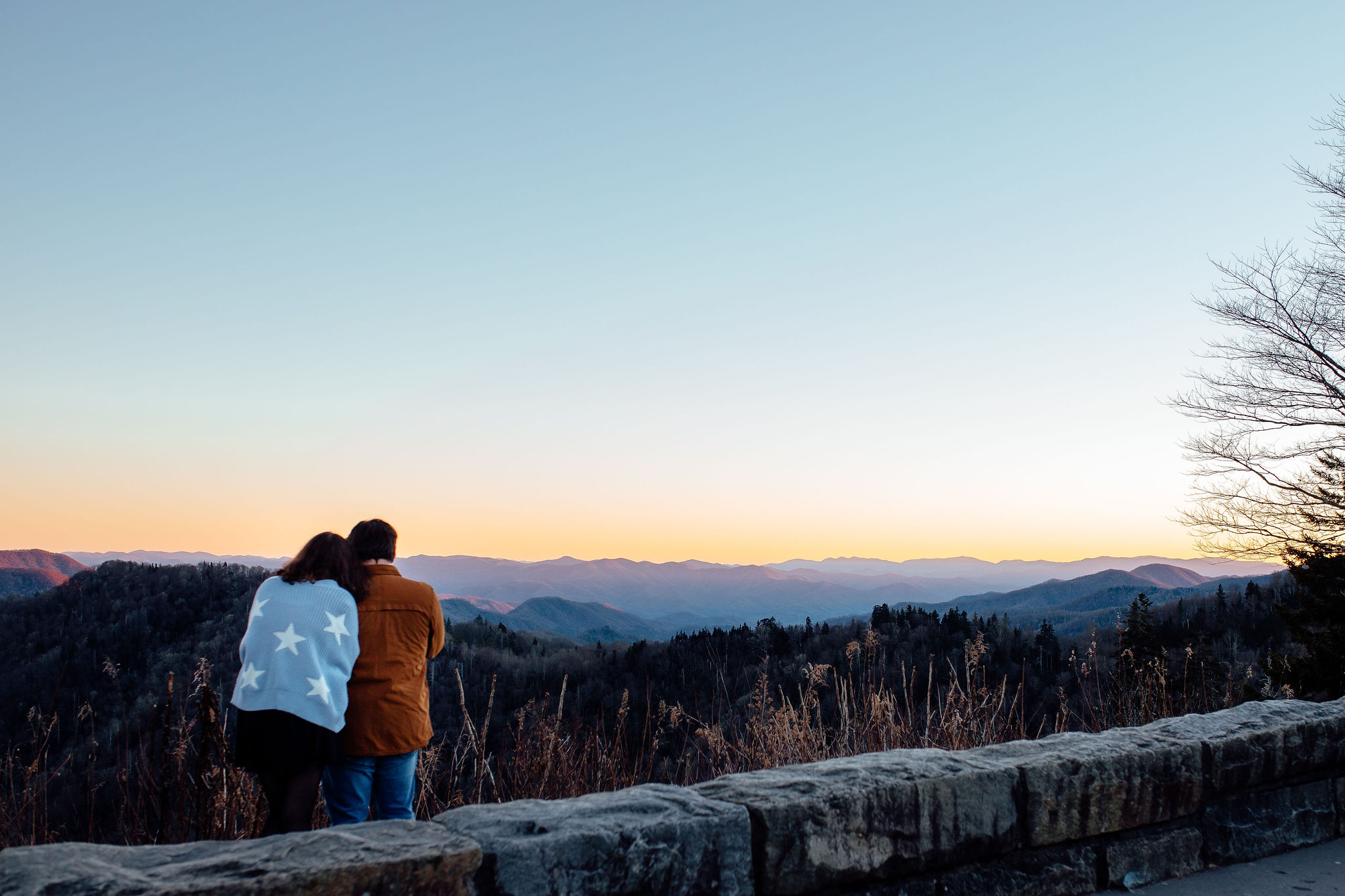 Couple snuggling as they watch the view of Newfound Gap